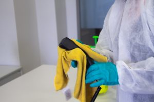 a professional cleaner in a protective suit cleaning