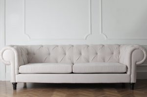 A white upholstered couch, representing how to clean different types of furniture. 